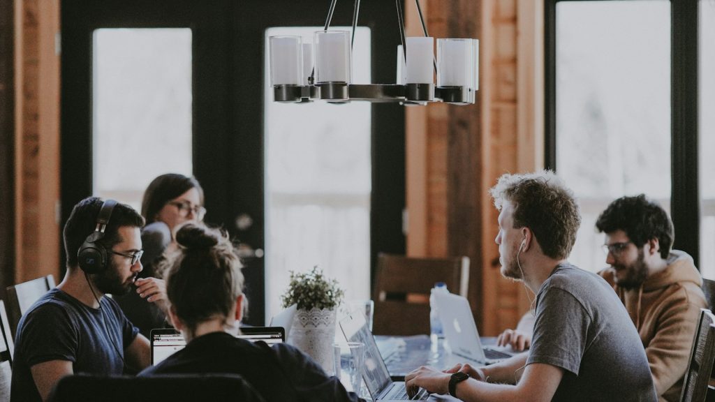 A software team working together around a table with laptops