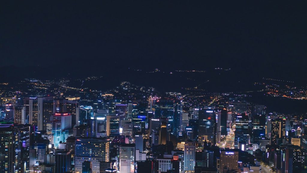 A city at night with tall lit buildings, the setting for connected IoT systems