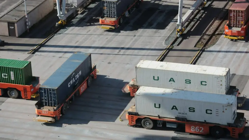 Automated guided vehicles carrying shipping containers at a port